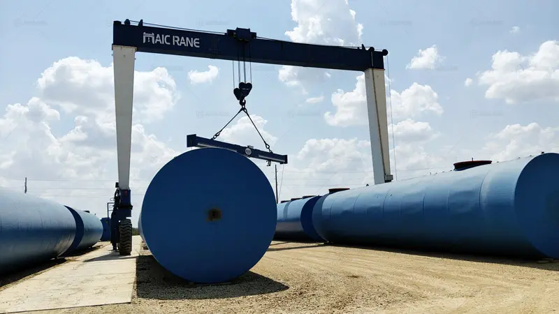 Grúa pórtico hidráulica YTL40T realizando la carga de tanques de acero en patio industrial