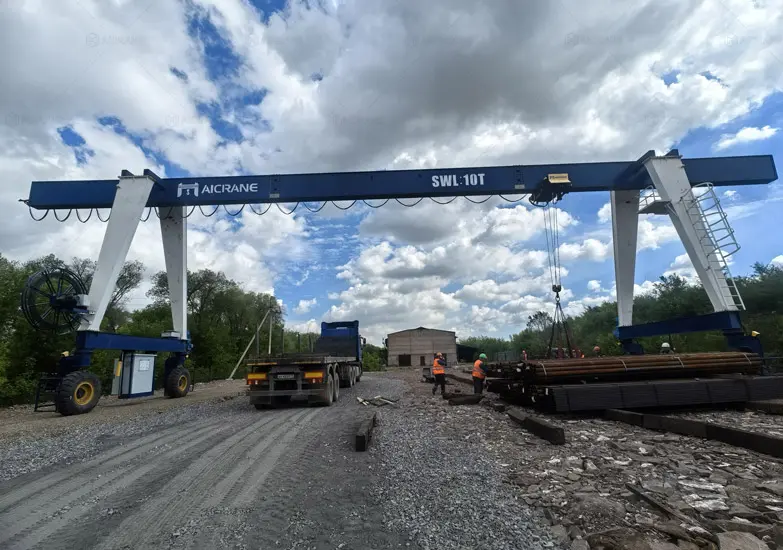Grúa Pórtico sobre Ruedas Manipulando Perfiles y Estructuras Metálicas en un Taller Industrial